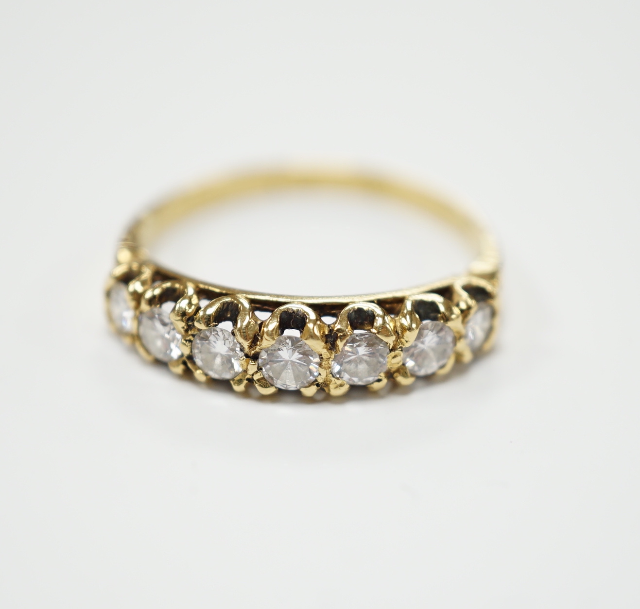 An 18ct gold and seven stone diamond set half hoop ring, size P, gross weight 2.7 grams.